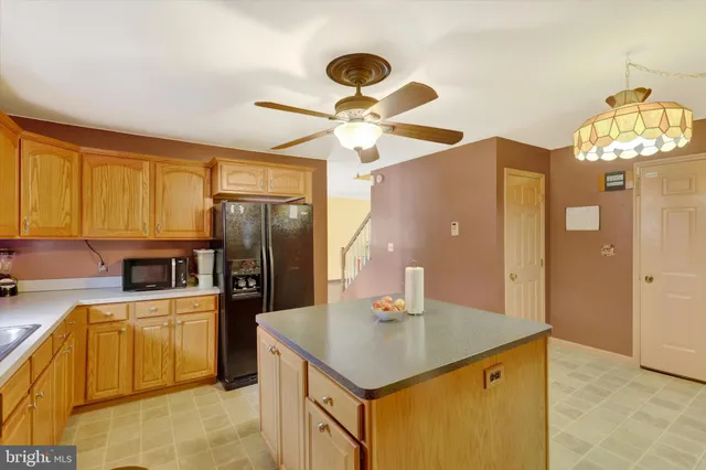 a kitchen with a sink stainless steel appliances and chandelier