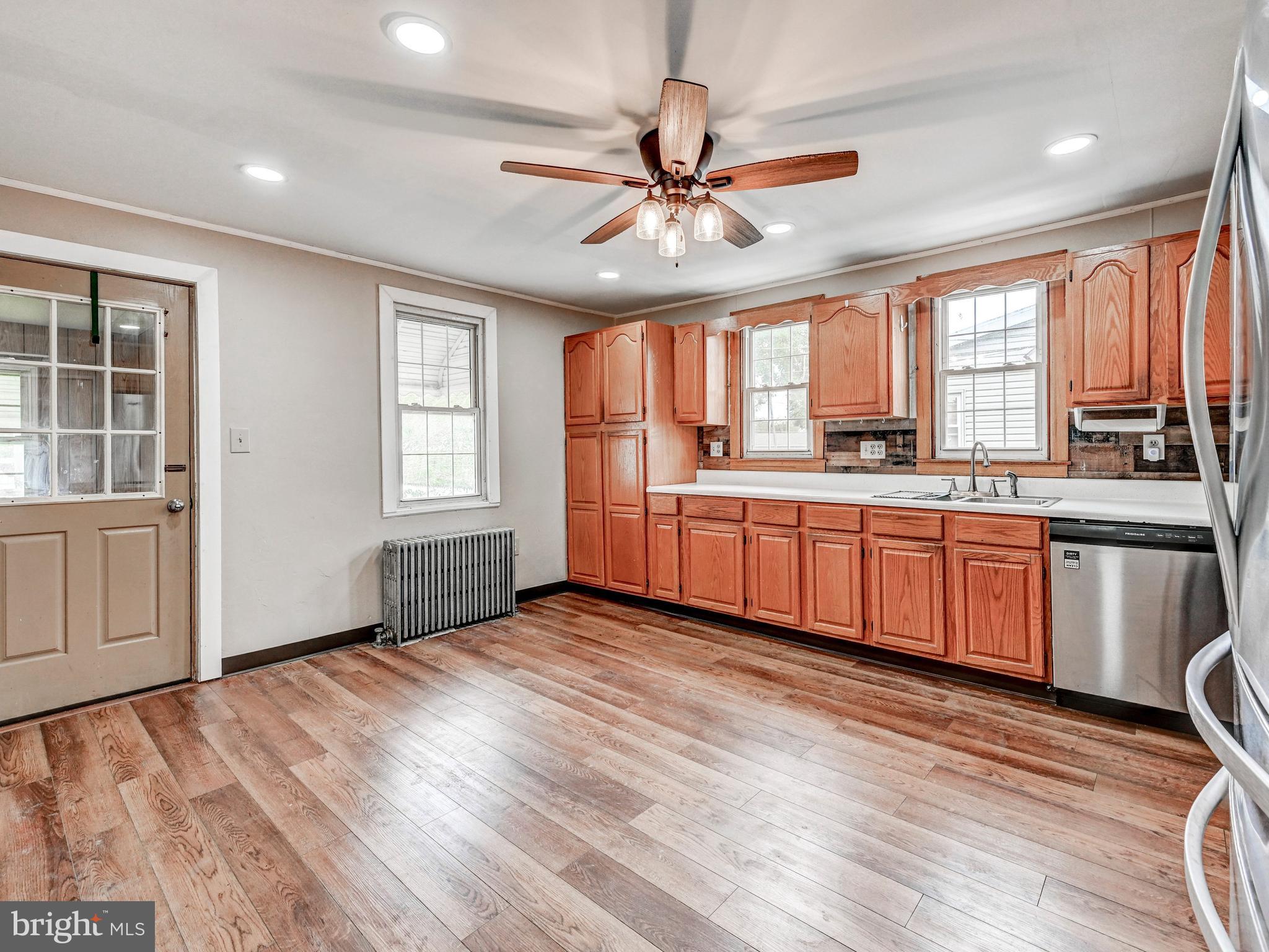 3206 Lynch Road Baltimore, MD 21219 - Photo 20 of 70 a kitchen with stainless steel appliances a sink cabinets wooden floor and a window