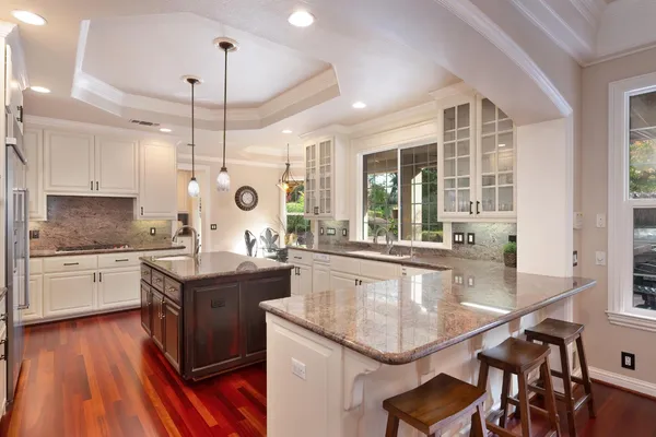 a view of living room with granite countertop chairs and couches with wooden floor