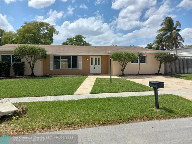 a front view of a house with a yard garden and outdoor seating