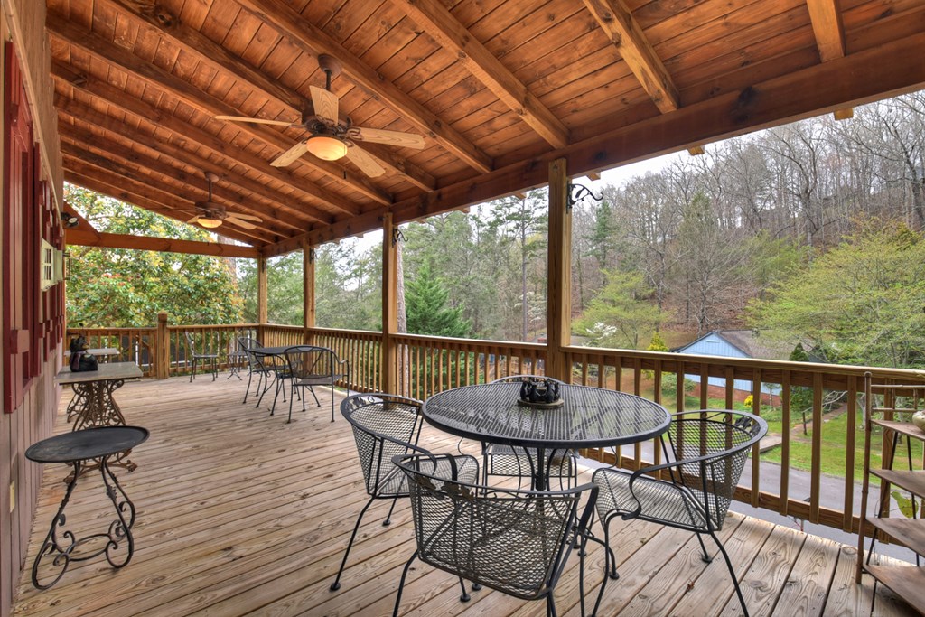190 Village Road Murphy, NC 28906 - Photo 27 of 50 a view of a patio with a dining table and chairs with wooden floor