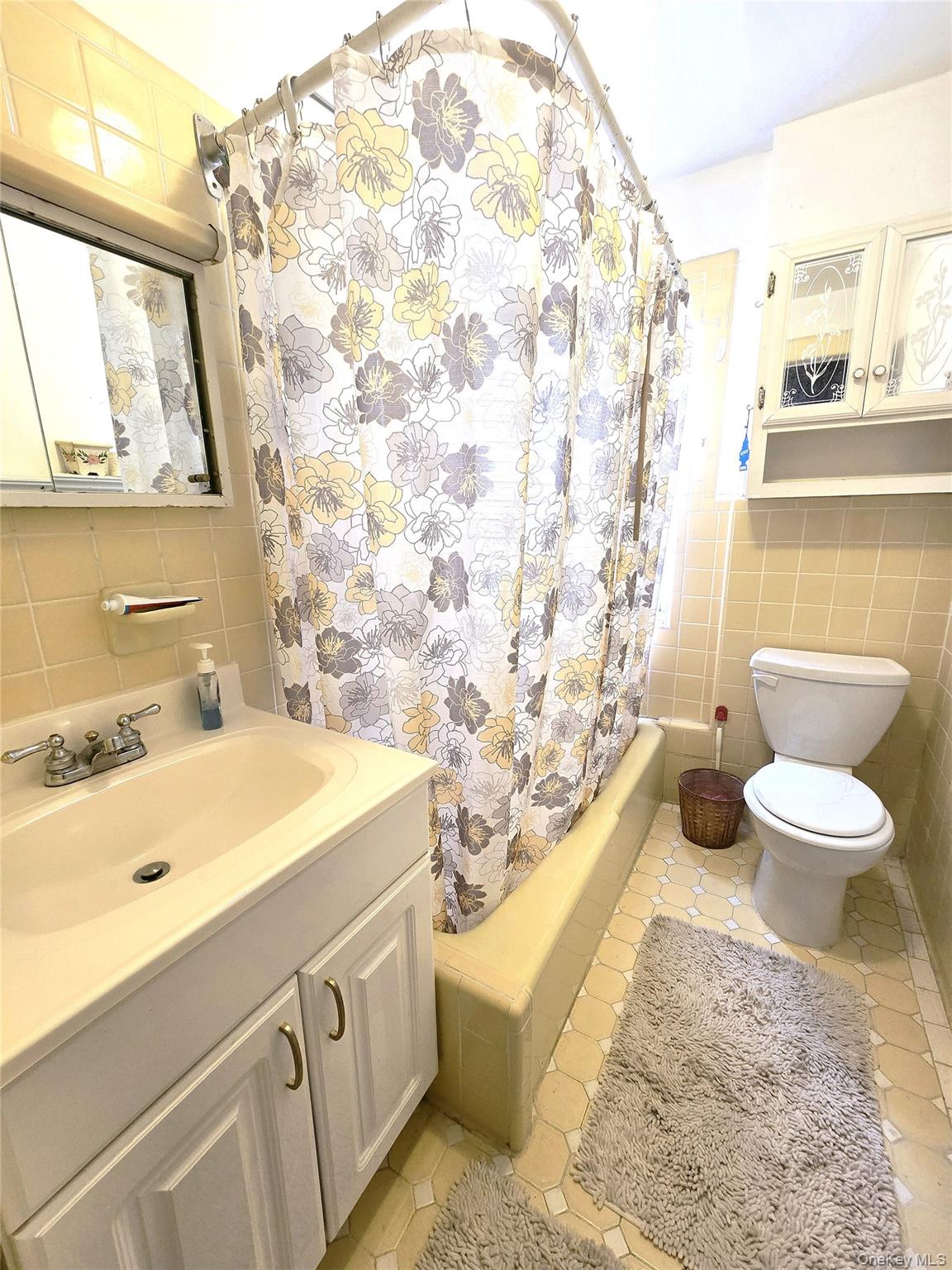 85-09 Sutter Avenue Queens, NY 11417 - Photo 6 of 12 Full bathroom with vanity, tile walls, shower / bath combination with curtain, and toilet