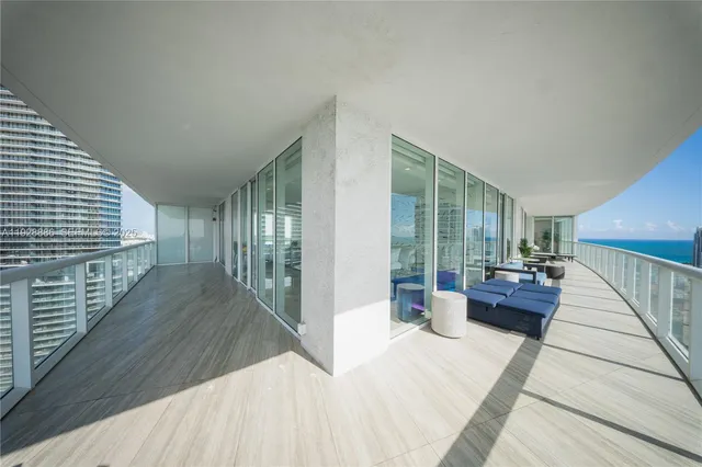 a living room with furniture large window and wooden floor