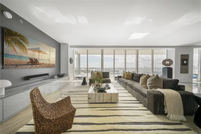 a living room with furniture and a floor to ceiling window