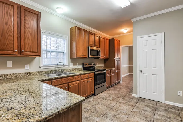 a kitchen with stainless steel appliances granite countertop a stove sink and cabinets