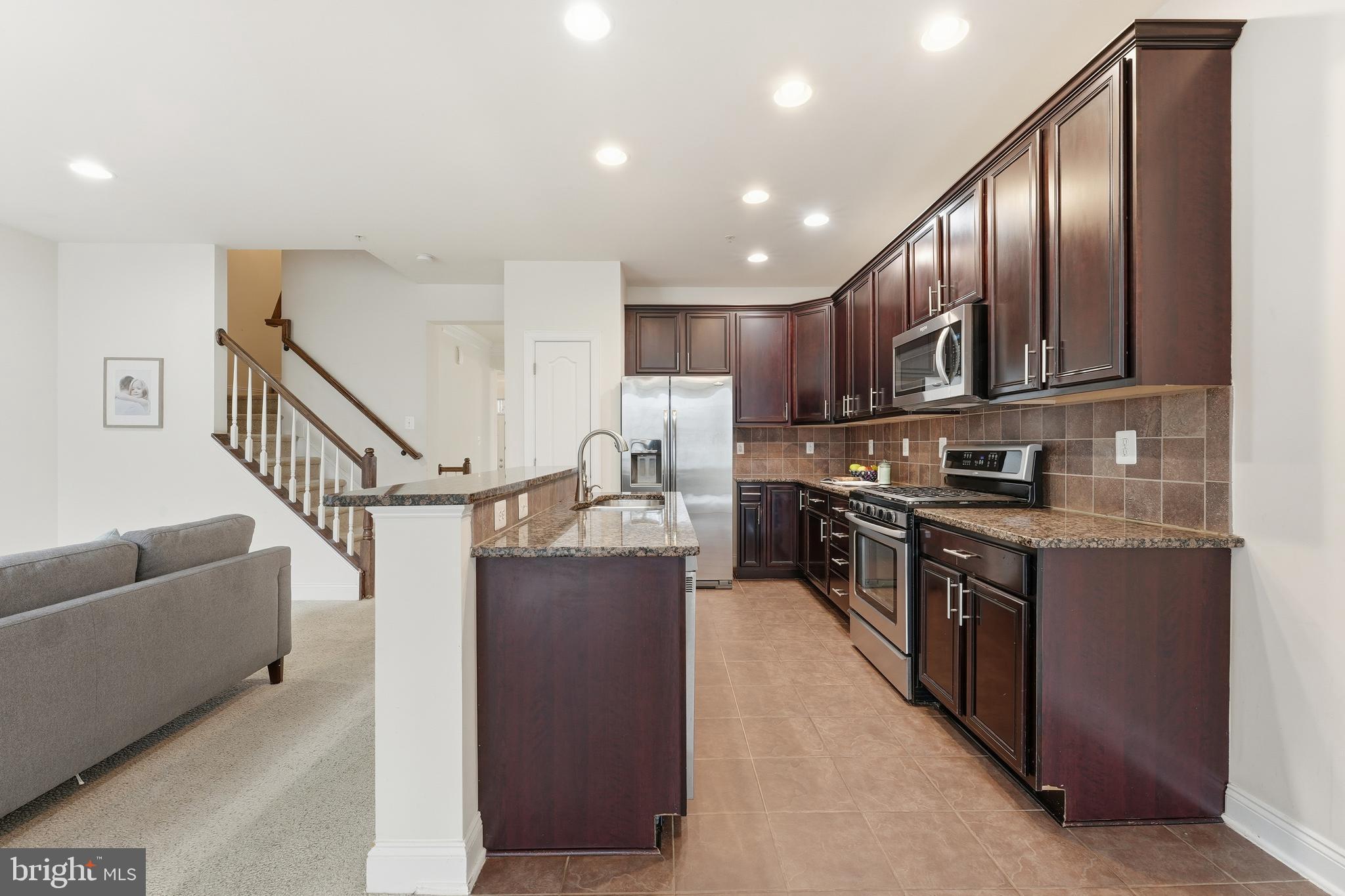 2284 Brimstone Place Hanover, MD 21076 - Photo 6 of 37 a kitchen with stainless steel appliances granite countertop a refrigerator a stove a sink and a microwave
