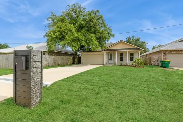a front view of a house with a garden