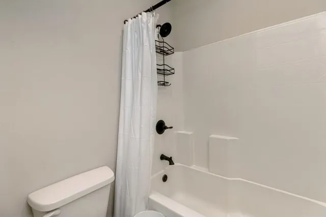 a bathroom with a shower a toilet and a shower