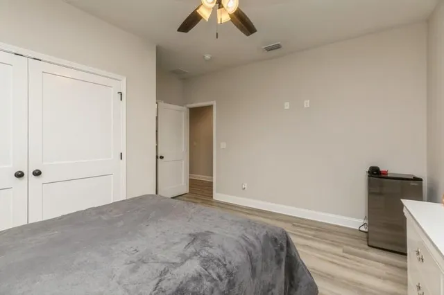 a view of a bedroom with a bed and a ceiling fan