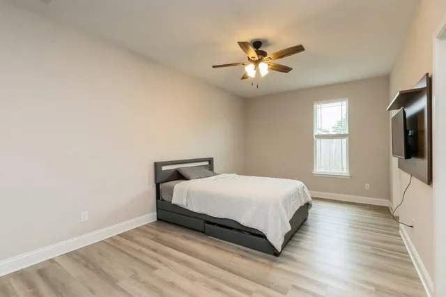 a bedroom with a large bed and a flat tv screen on a dresser