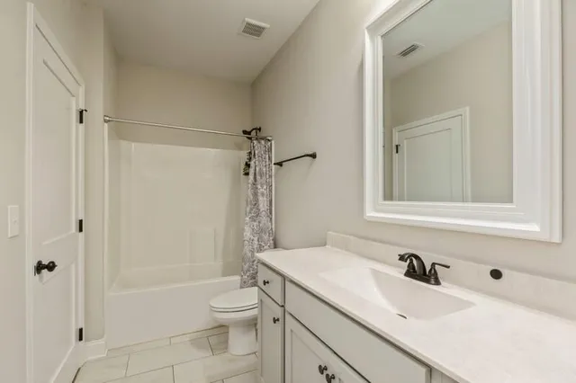 a bathroom with a sink toilet vanity and shower