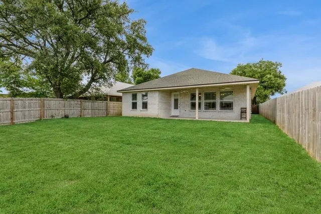 a view of a house with a backyard