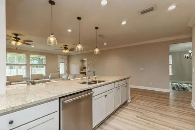 a kitchen with a sink stove and wooden floor