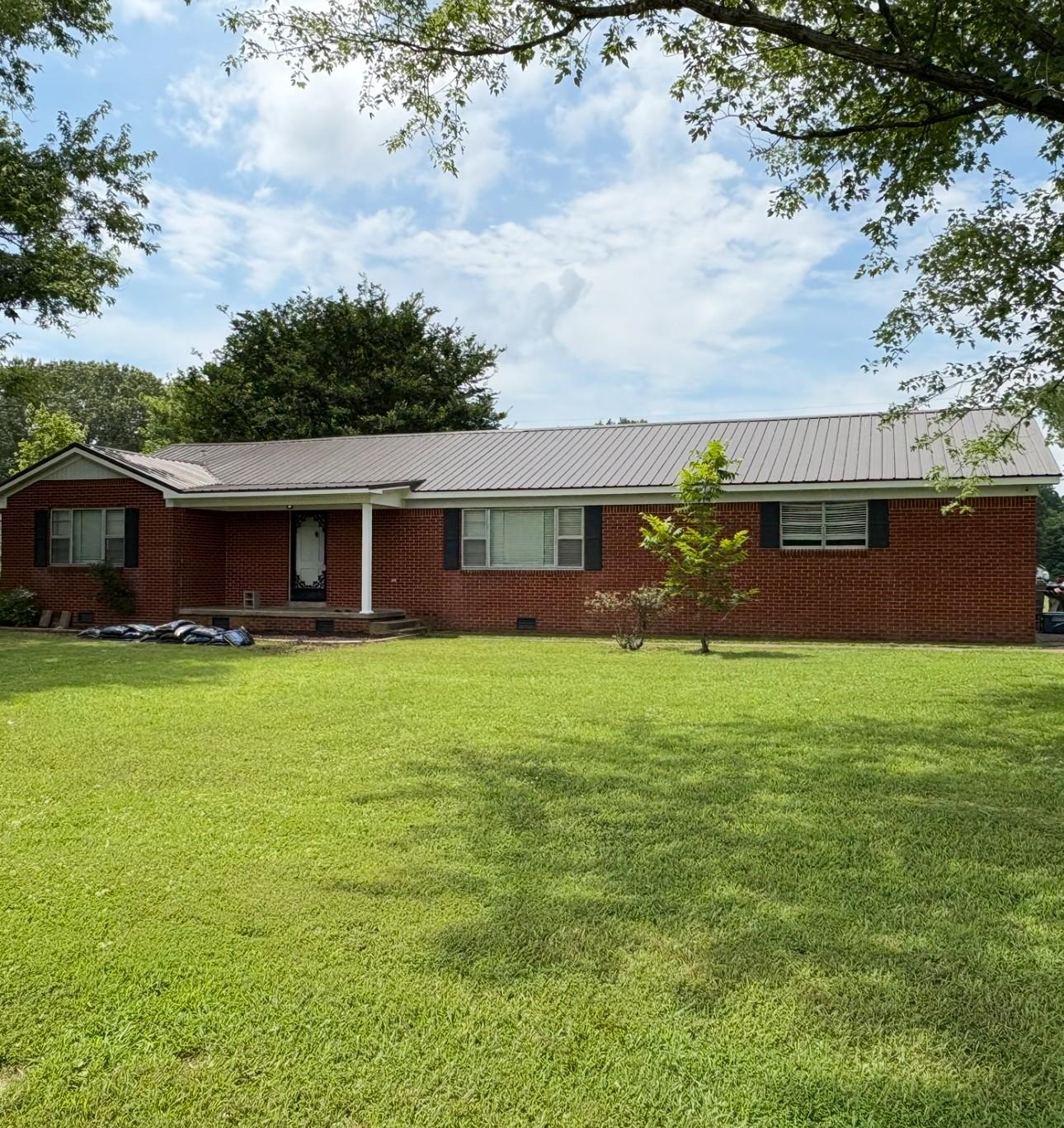 a front view of house with a garden
