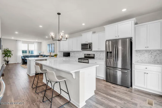 a kitchen with kitchen island white cabinets and stainless steel appliances