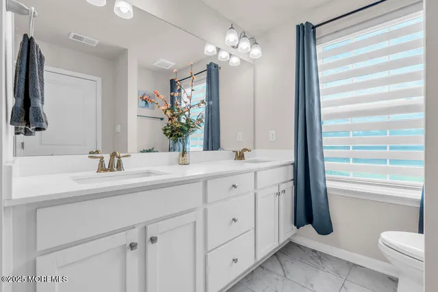 a bathroom with a double vanity sink and a mirror