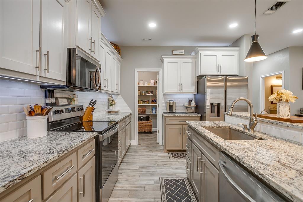 409 Titus Drive Springtown, TX 76082 - Photo 11 of 39 a kitchen with stainless steel appliances granite countertop a sink stove and refrigerator