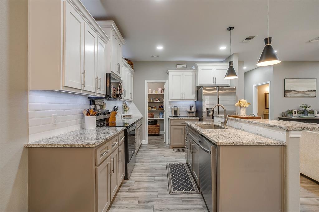 409 Titus Drive Springtown, TX 76082 - Photo 15 of 39 a kitchen with stainless steel appliances granite countertop sink stove and refrigerator