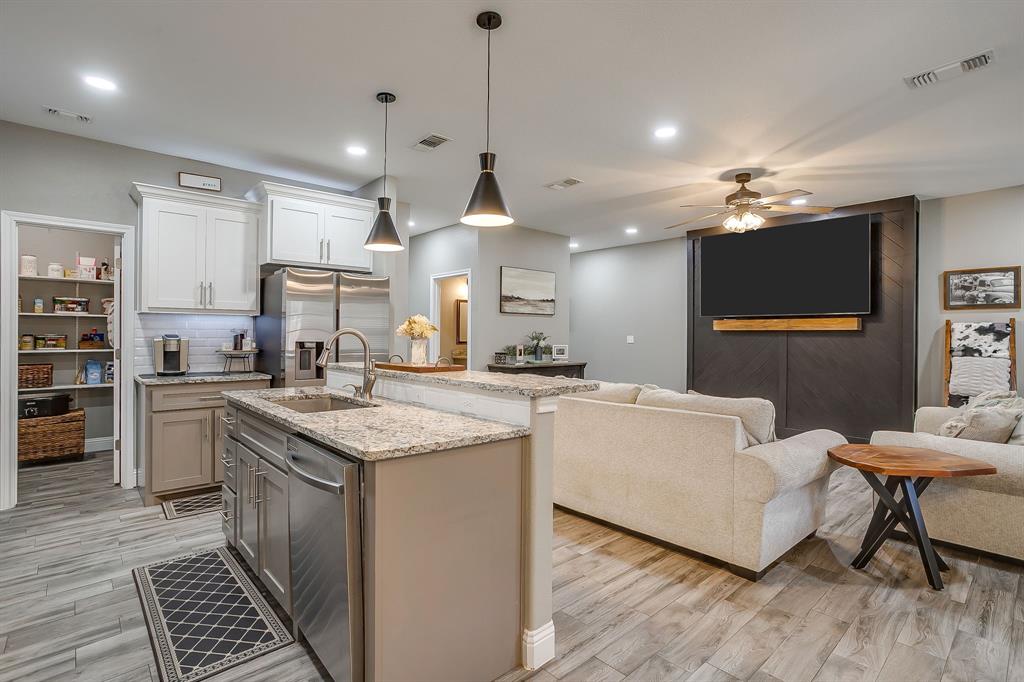 409 Titus Drive Springtown, TX 76082 - Photo 16 of 39 a kitchen with stainless steel appliances granite countertop a stove and a wooden floors