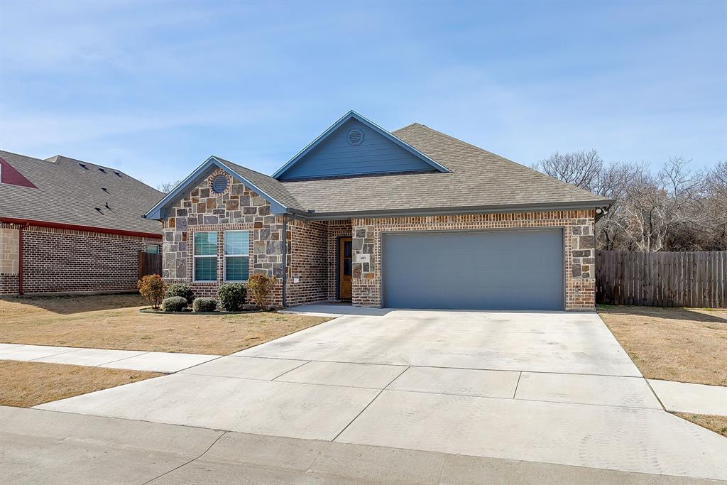 409 Titus Drive Springtown, TX 76082 - Photo 2 of 39 a front view of a house with a yard and garage