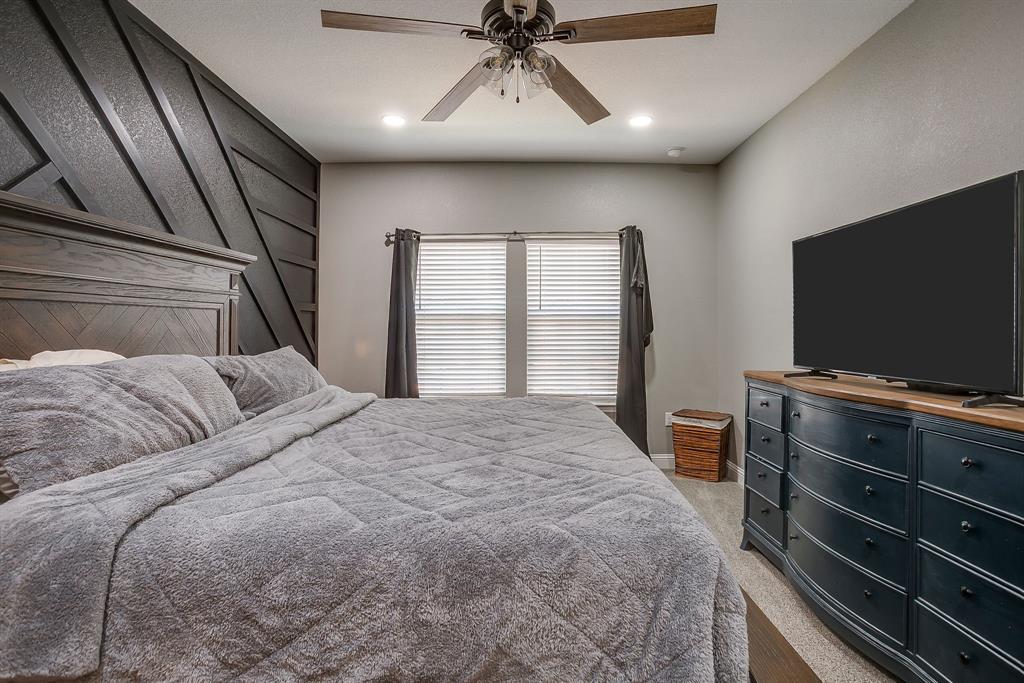 409 Titus Drive Springtown, TX 76082 - Photo 21 of 39 a bedroom with a bed and a flat screen tv