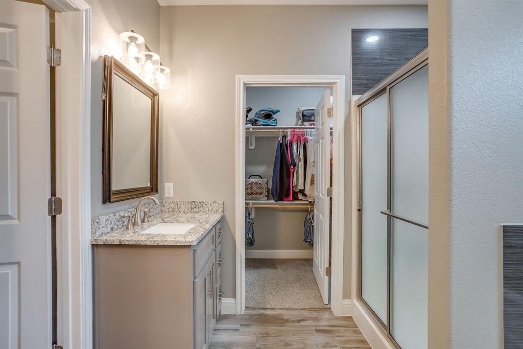 409 Titus Drive Springtown, TX 76082 - Photo 23 of 39 a en suite bathroom with a granite countertop sink and a mirror