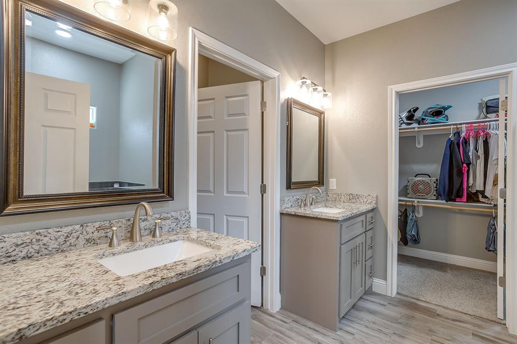 409 Titus Drive Springtown, TX 76082 - Photo 24 of 39 a bathroom with a granite countertop double vanity sink and a mirror