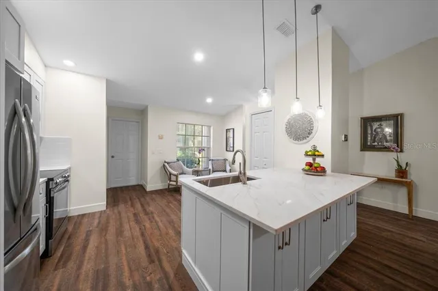 a kitchen with a sink stove and wooden floor