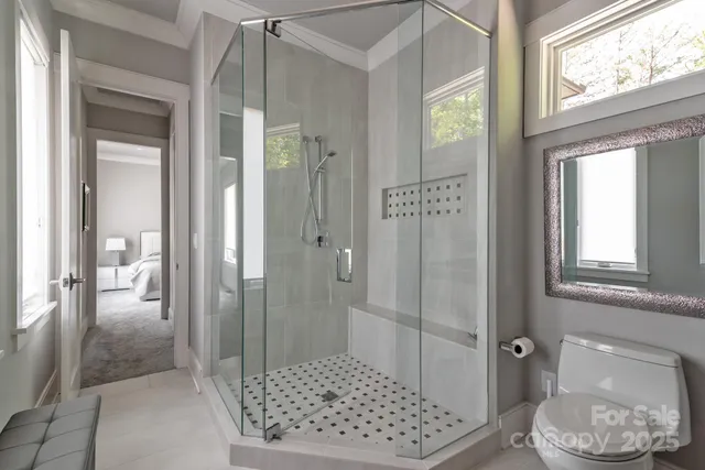 a bathroom with a glass shower door and a window