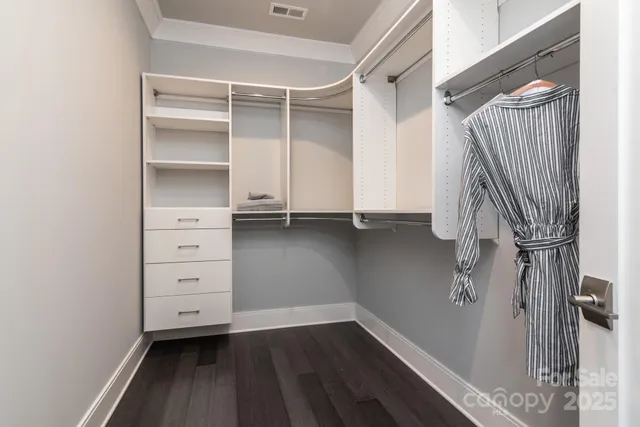 a view of walk in closet with empty racks