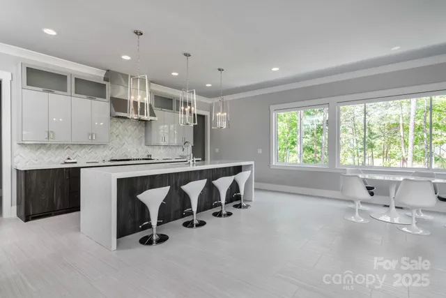 a large kitchen with kitchen island a large counter top space a sink and appliances