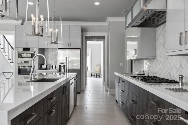 a kitchen with stainless steel appliances granite countertop a sink a stove and a refrigerator