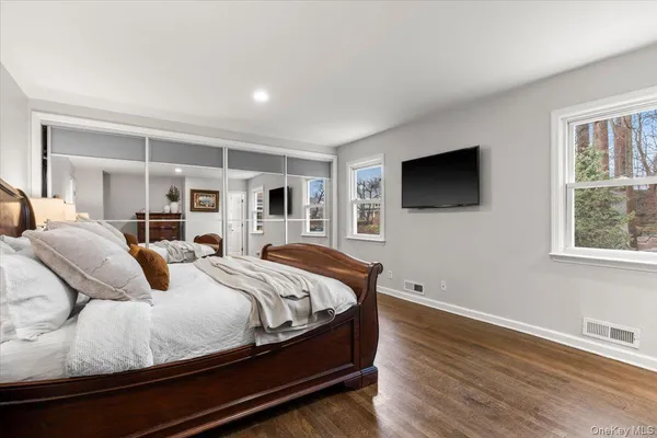 a bedroom with a large bed and a flat screen tv