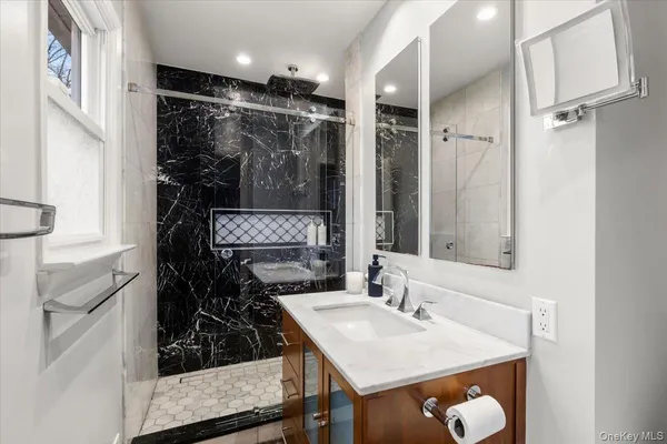 a bathroom with a sink mirror and shower