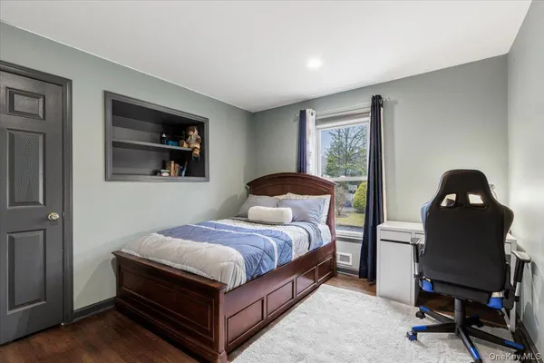 a bedroom with a bed and a painting on the wall