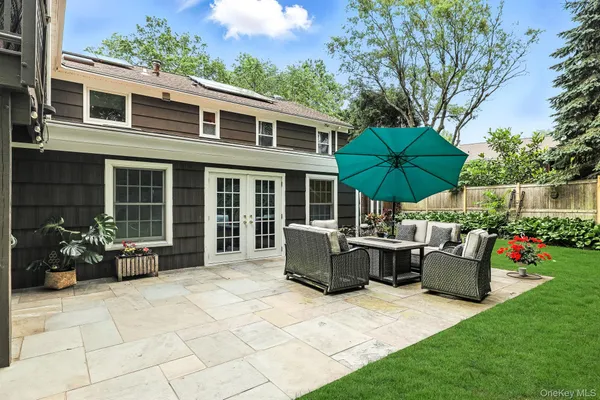 a patio with a table and chairs under an umbrella