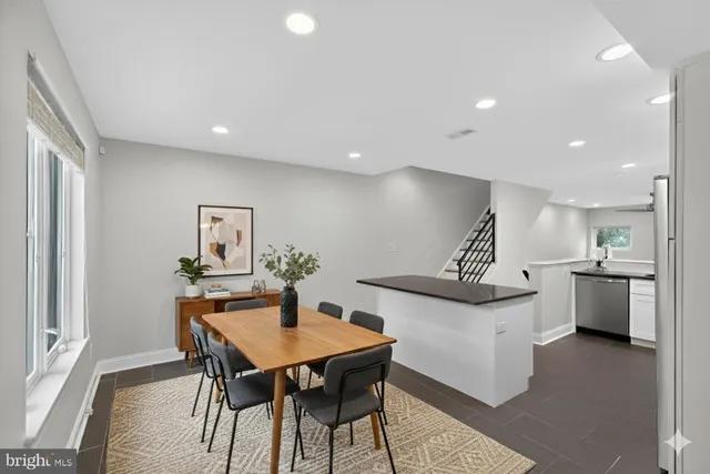 a kitchen with stainless steel appliances kitchen island a table and chairs in it