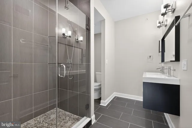 a bathroom with a sink shower and a mirror