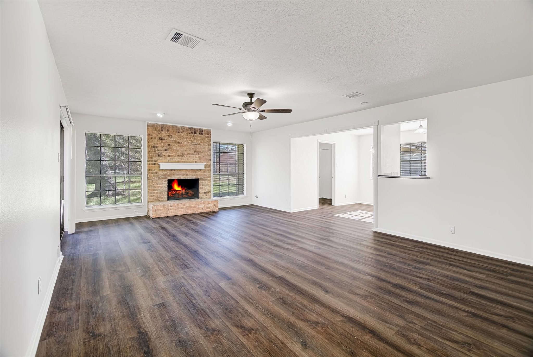 216 Any Way Street Lake Jackson, TX 77566 - Photo 8 of 49 an empty room with wooden floor fireplace and windows