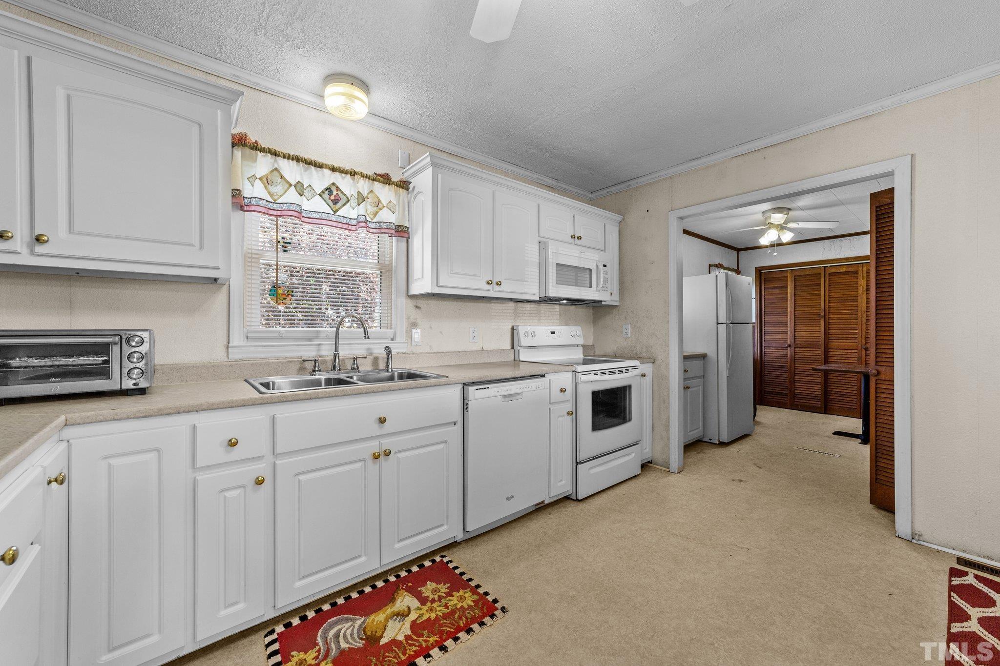 2255 Blalock Dairy Road Roxboro, NC 27574 - Photo 23 of 27 a kitchen with granite countertop white cabinets and white appliances