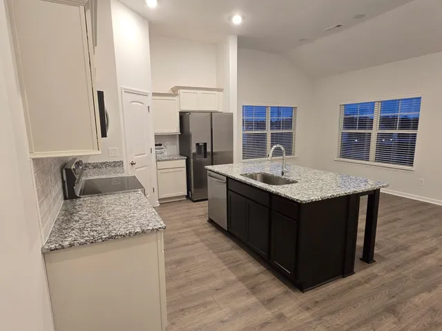 a kitchen with stainless steel appliances granite countertop a sink stove and refrigerator