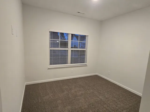 en empty room with windows and ceiling fan