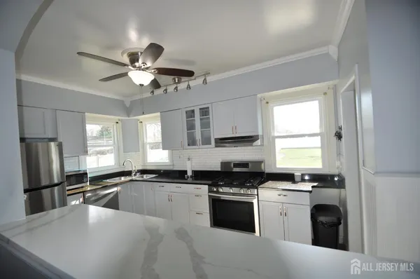 a kitchen with a sink stainless steel appliances and window