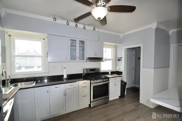a kitchen with stainless steel appliances white cabinets and a sink