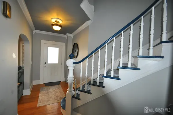 a view of staircase with wooden floor and a chandelier