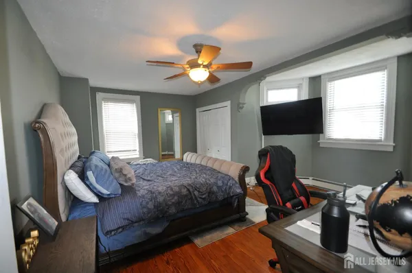a bedroom with bed tv and window