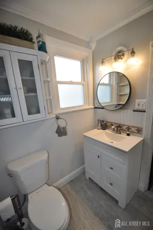 a bathroom with a sink mirror vanity and toilet