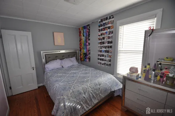 a bedroom with a bed and a dresser next to a window