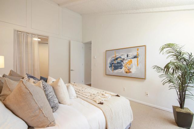 a bedroom with a bed and a painting on the wall