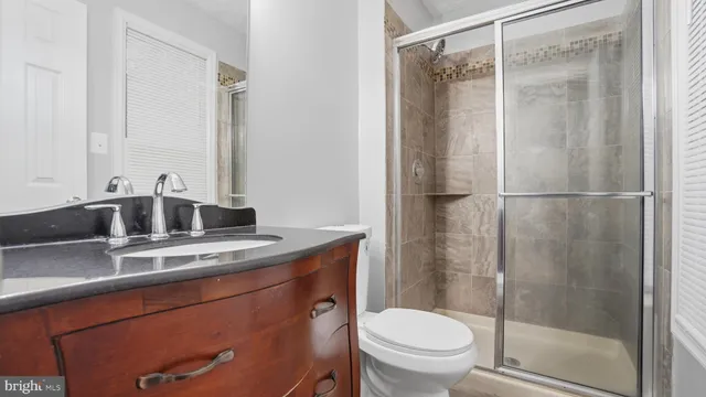 a bathroom with a granite countertop sink toilet and shower